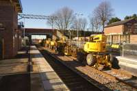 A lineup of road-rail aerial platforms for use on the Liverpool - Manchester electrification project parked on the reinstated but as yet unused platform 4 at Roby station on 3 February 2015. View west towards Liverpool Lime Street.<br><br>[John McIntyre 03/02/2015]