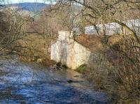 With less than half a mile to go before joining the Tweed, the Gala Water flows past the surviving northern abutment of the railway bridge that once carried the Selkirk branch across the river. Looking north west towards Galashiels station on 8 February 2015 from the pedestrian footbridge off Galafoot Lane. The recently laid tracks of the Borders Railway run between the mesh fences.<br><br>[John Furnevel 08/02/2015]