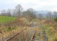 Looking south from the site of Festiniog station at Llan Ffestiniog towards Trawsfynydd in March 2015. The line closed in 1961 but reopened for traffic to the nuclear power station in 1964. The last flask train ran in 1998 when Trawsfynydd closed but the disused tracks remain. [Ref queries 2931 / 4434]  <br><br>[Mark Bartlett 15/03/2015]