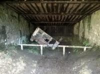 The inside of the catch pit at the bottom of Sheep Pasture Incline in March 2015, showing the remains of a wagon that demonstrates the value of the system.  The catch pit was installed in 1888 after two loaded wagons ran away almost from the top and were travelling at such speed they jumped the Cromford Canal and Midland Railway just beyond.  This particular wagon was safely arrested after its unrestrained journey down the bank in 1946. [see Image 50904]<br><br>[Malcolm Chattwood 18/03/2015]