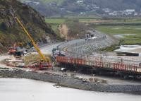 Progress at Pont Briwet on 17th April 2015: all traces of the original trestle bridge have gone and construction of the new concrete road bridge is well under way.<br>
Llandecwyn station is complete and now has lighting and a Passenger Information System. [See image 49098]<br><br>[Colin McDonald 17/04/2015]