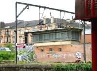 The old Muirhouse Junction signal box seen from the door of a train standing in Pollokshields East station in August 2006. The tenements of Darnley Street form the backdrop. <br><br>[John Furnevel 11/08/2006]
