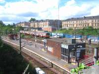 View over Pollokshields East station from Albert Drive in August 2006. In the background a northbound train is passing the disused signal box at Muirhouse Junction heading for Glasgow Central.<br><br>[John Furnevel 11/08/2006]