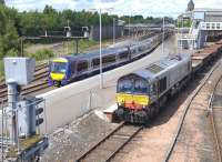 DRS 66423 passes ScotRail 170 and 158 units stabled in bay platform 5 at Perth station on 28 June 2015 with a Moy - Millerhill spent ballast train.<br><br>[Bill Roberton 28/06/2015]