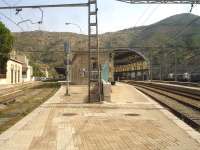 View south along the lengthy platform at Portbou, first station in Spain on the line running between Perpignan and Barcelona Sants, with the external easternmost lines on the left showing a lack of regular use. These lines are standard gauge, electrified at 25KV for the occasional SNCF services that run beyond Cerbere. A 3 coach Rodalies de Catalunya EMU can just be seen under the station roof, after arrival on a service from Barcelona Sants, and a number of Renfe Mercancias Bo-Bo electric freight locos are stabled over on the right. The large freight yard is located beyond the stabled locomotives.<br><br>[David Pesterfield 07/08/2015]