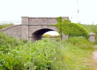 Granite bridge over the trackbed of the Peterhead Quarry Railway at Lendrum Terrace, two and a half miles south of the Harbour and Prison at Peterhead. The line ran from Stirlinghall Quarry, south of this bridge to the Harbour of Refuge, carrying granite for the great breakwaters and convict labour to the quarry. The bridge, as other structures on the line, built to exacting Admiralty design standards and an example of exceptional craftsmanship - far above what would be expected of an 'industrial' railway.<br><br>[Brian Taylor 20/06/2015]