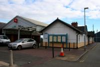 The entrance to Pwllheli station at the north end of the building on 14th October 2015. The building on the left is a discount store built on the site of the north part on the former island platform and its release road.<br><br>[Colin McDonald 14/10/2015]
