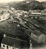 The high level goods yard above Oban in a view looking north east. The approach to the pier can't be seen - it is in a cutting beyond the cottage seen in the foreground. There is an engine shunting at the far end of the yard.<br><br>
<br><br>
The cattle market is to the right. The incomplete and abandoned hydro is prominent on the hillside above the town.<br><br>
<br><br>
The building at the bottom right is the coaling canopy on one of the approach roads to the engine shed (out of shot to the right) - publisher touching up of this postcard view has converted it into what looks like a house. This was removed when the coaling plant was installed by the LMS. <br><br>
<br><br>
This area has been redeveloped - the yard closed in 1969 (an oil siding surviving until the early 1990s) and the cattle market has been relocated further south.<br><br>[Ewan Crawford Collection //]