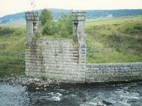 The castellated southern abutment of the Dulnain Bridge in August 1982 in a view looking to Broomhill. The girders had been removed after closure in 1965 and it would be another thirty three years before the new girders were laid by the Strathspey Railway as they reconstructed the line to Grantown-on-Spey. [See image 46310]<br>
<br><br>[Peter Todd /08/1982]