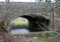 The tail of the platform still remains under Station Road at Gordon. This view looks under the bridge at the station and towards Duns.<br><br>[Ewan Crawford 06/03/2016]
