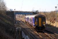 A Glasgow Queen Street to Falkirk Grahamston service on the crossover approaching Cowlairs South Junction passes under Fountainwell bridge which is due to be demolished shortly (March 2016.) Photographed from Sighthill cemetery grounds. <br><br>[Colin McDonald 14/03/2016]