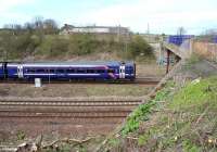 The 0845 Tweedbank - Edinburgh about to pass below Whitehill Road bridge as it slows for the stop at Newcraighall station on 17 April 2016. A photograph from this position has only recently become possible following the cutting back of trees and shrubs along the embankment running south from the bridge towards Millerhill Yard.<br><br>[John Furnevel 17/04/2016]