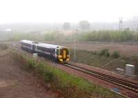ScotRail 158736 emerges from the fog at Millerhill on Sunday 8 May 2016 with the first Borders Railway southbound train of the day, the 0911 Edinburgh – Tweedbank. The train is in the process of passing over the double-track split at Newcraighall South Junction. In less than half a mile it will reach Shawfair station where it is scheduled to cross the first train north, the 0845 Tweedbank - Edinburgh. Part of the Millerhill Yard admin block is just visible in the right background. <br><br>[John Furnevel 08/05/2016]