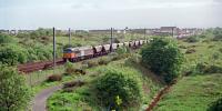 Class 56110 passing Stevenston with a loaded coal train from Hunterston in 1999. Behind the 3rd and 4th wagons (from the left) is the abutment of the Caledonian flyover.<br><br>[Ewan Crawford //1999]