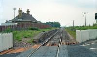 View east at the former Kinloss station in 1990. This station was relocated further east to the junction of the branch to Findhorn on its opening and returned to the original location on closure of the branch. The building dates form the third incarnation. Note the westbound platform on the right, now obscured by foliage.<br><br>[Ewan Crawford //1990]