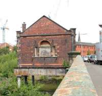 The old booking office at Partick Central standing above the overgrown platform remains in August 2006. View is east along the bridge carrying Benalder Street over the River Kelvin, running directly below the camera. At this stage planning was well advanced on redevelopment of the area and the whole site would be cleared within 6 months [see image 13369].<br><br>[John Furnevel 27/08/2006]