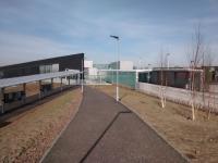 The street approach to seen on 27/03/2017. The tram stop is on the left with the station on the right. A distinct lack of people around, as is my experience of this place so far. Give it time, though ...<br><br>[David Panton 27/03/2017]