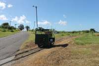Motor trolley at the La Vallee turning circle of the St Kitts Scenic Railway. The trolley runs ahead of the passenger train with the driver operating some of the level crossing barriers. It is sitting on the points leading to the disused west coast section of the line to Basseterre which continued south from here.