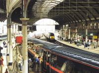 Busy platform scene at Newcastle Central in April 1997, with a GNER Kings Cross - Edinburgh train boarding at platform 2, as the up <I>Highland Chieftain</I> runs into platform 3. A Pacer stands at bay platform 1 in the left background.<br><br>[John Furnevel 05/04/1997]