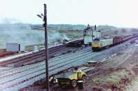 Unidentified Class 47 diesel photographed heading north with a freight train on the newly opened (that morning) junction deviation at Barassie, Monday, 29 November, 1982, the redundant Signalbox (officially closed the day before) already being demolished and its funeral pyre emitting plenty of smoke. The old 'Down' (to Irvine) line behind the Signalbox was later lifted but the 'Up' line was retained, the Kilmarnock line running into this line (with facing connection off the re-aligned main line at the south end of Barassie station platforms), the route south onto the Troon avoiding line became the run-round loop in Barassie Yard, and the old alignment onto the Troon Loop and Troon station became the 'up' loop.<br><br>[Robert Blane 29/11/1982]
