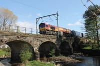 DB 66145, still in EWS livery, crosses the River Wyre at Scorton heading north with a container train on a sunny 22nd April 2017.<br><br>[Mark Bartlett 22/04/2017]