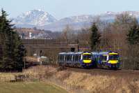 Dunblane-Edinburgh (170 410) and Glasgow-Alloa (170 474) services pass each other near the site of Polmaise Junction on 25th March 2017. The snowy peak of Uamh Bheag looms in the background. <br><br>[Mark Dufton 25/03/2017]