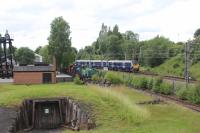 334024 passing the site of Sunnyside Junction signal box in July 2017, with the track into Gunnie Yard still visible. To the left is the entrance to the mock drift mine at Summerlee Heritage Park and also visible alongside the main line are NCB No.9 and two other preserved industrial locomotives. <br>
<br><br>[Alastair McLellan 12/07/2017]