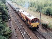 A trainload of coal empties on its way back to Ravenstruther restarts from a signal check at the north end of Millerhill Yard in June 2000. The locomotive is EWS 66051. <br><br>[John Furnevel 05/06/2000]