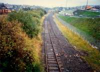Looking west to Airdrie station (distant 303 in bay platform). In distant left the former Caley line crosses a bridge, then crossed the NB line by means of a missing bridge and terminated at a station in the carpark to the right.<br><br>[Ewan Crawford //1987]