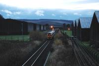 Westbound train passes bonded warehouses west of Keith.<br><br>[Ewan Crawford //]