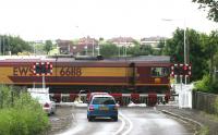 EWS 66118 on Halbeath level crossing in June 2006 in the process of running round the coal train which it has just dropped in Halbeath sidings. The remains of Halbeath station are just off picture to the right. <br><br>[John Furnevel 13/06/2006]